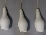three white vases hanging from the ceiling of a room