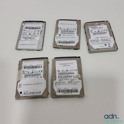 four hard drives sitting on top of a white table next to each other