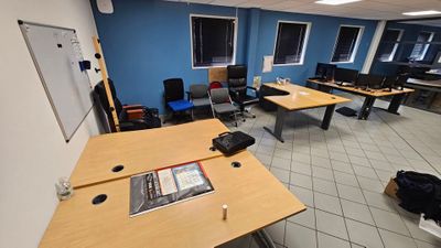 une photo d'une salle remplie de bureaux et de chaises