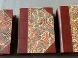 three books are lined up in a row on a table