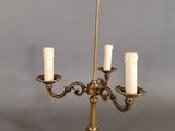 un chandelier ancien en laiton à cinq bougies, posé sur un socle
