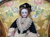 a doll that is sitting on a chair in a room