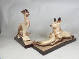 two figurines of animals that are sitting on a table