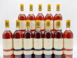 plusieurs bouteilles de vin sont alignées sur une surface blanche