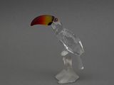 une figurine en verre représentant un toucao perché sur une branche