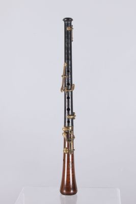a black and gold clarinet on a clear surface