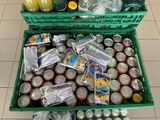 a green crate filled with cans of soda and oranges
