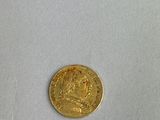 a close up of a gold coin on a white surface