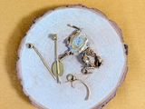 une petite assiette posée sur une table, sur laquelle se trouvent quelques bijoux