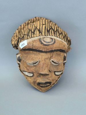 une image représentant un masque en bois sur fond gris