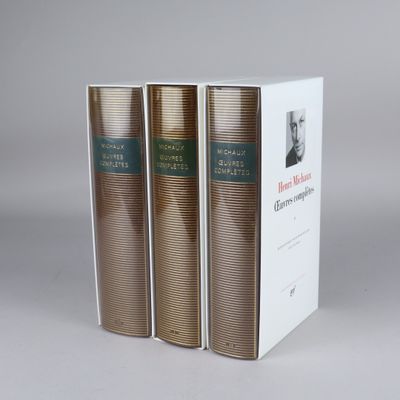 three books sitting on top of each other on a white surface