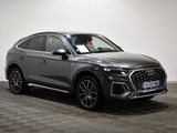 a grey audi suv parked in a showroom with a checkered floor