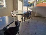 tables and chairs in a room with a view of a city