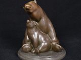 bronze sculpture of a bear and a cat on a black background