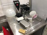 a kitchen sink with a lot of dishes and utensils on it