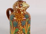 a brown and green vase with a bird on it
