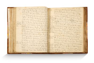 un livre ouvert avec une écriture dessus, posé sur une table