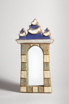 a small blue and white mirror with birds on it