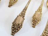 five spoons and two spoons on a white table