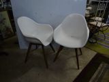 two white chairs sitting next to each other in a room