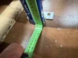 a person measuring a piece of wood with a tape