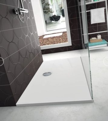une douche avec une porte vitrée au milieu de la salle de bains