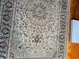 un tapis posé par terre, à côté d'une lampe et d'un livre