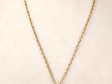 un collier en or avec une pièce de monnaie sur le cou d'un mannequin