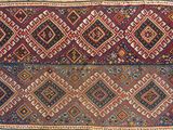 a close up of a colorful rug on a stone surface