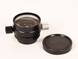 un objectif d'appareil photo et un cache-objectif posés sur une surface blanche