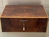 a wooden box with a key hanging from it ' s side