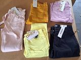 several pairs of colored pants are on a cardboard box