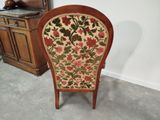 a chair with a floral upholstered seat in a room