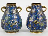 une paire de vases bleus avec des anses dorées sur fond blanc