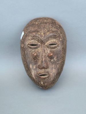une image représentant un masque en bois sur lequel est peint un visage