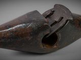 an old pipe is sitting on a white surface with a gray background