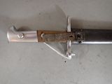 a knife with a wooden handle on a white surface