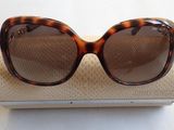 des lunettes de soleil marron posées sur une boîte blanche, sur fond blanc