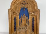 une vieille sculpture en bois représentant un groupe de personnes devant un fond bleu