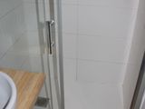 a white sink and a shower in a small bathroom