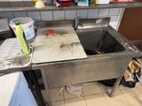 a dirty sink in the middle of a dirty kitchen