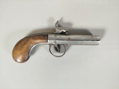 an old revolver with a wooden handle on a white surface