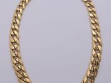 a gold necklace on a white background