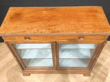 an antique wooden display cabinet with glass doors and drawers