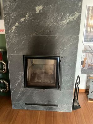 une cheminée au milieu d'une pièce au sol en parquet
