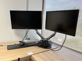 a desk with two monitors and a keyboard on it