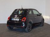 the small black car is parked in a room with a checkered floor