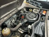 un moteur de voiture dont le capot est ouvert, garé dans la rue