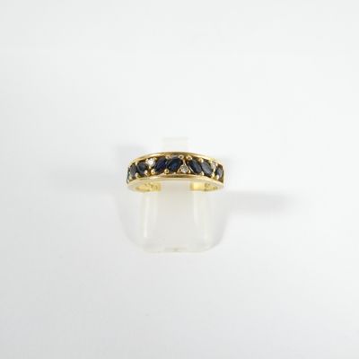 a close up of a gold ring with blue sapphire stones