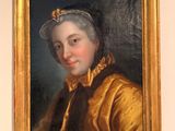 portrait of a woman in a gold dress and a hat